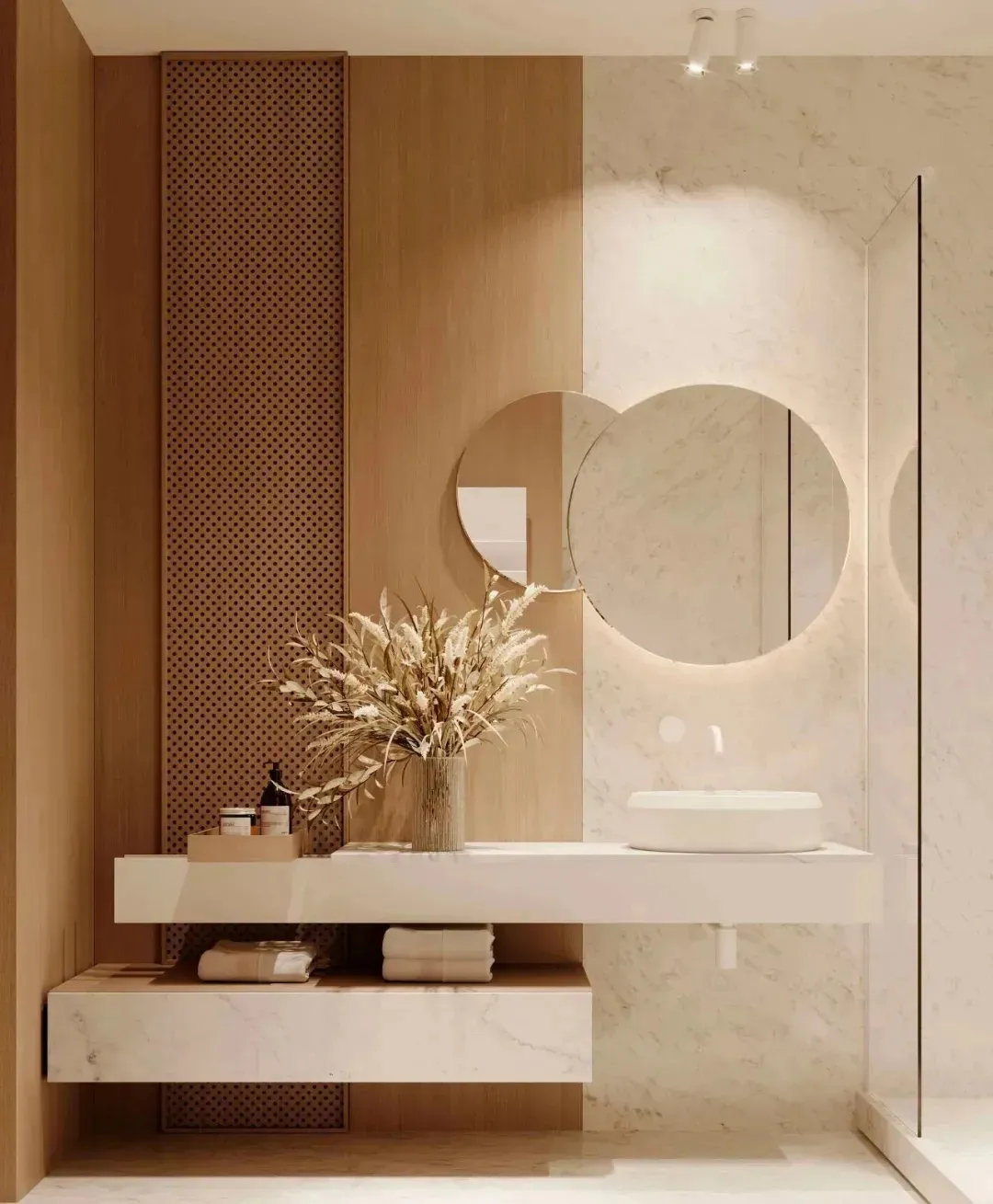 Modern bathroom with marble walls, floating vanity, and round mirror with ambient lighting.