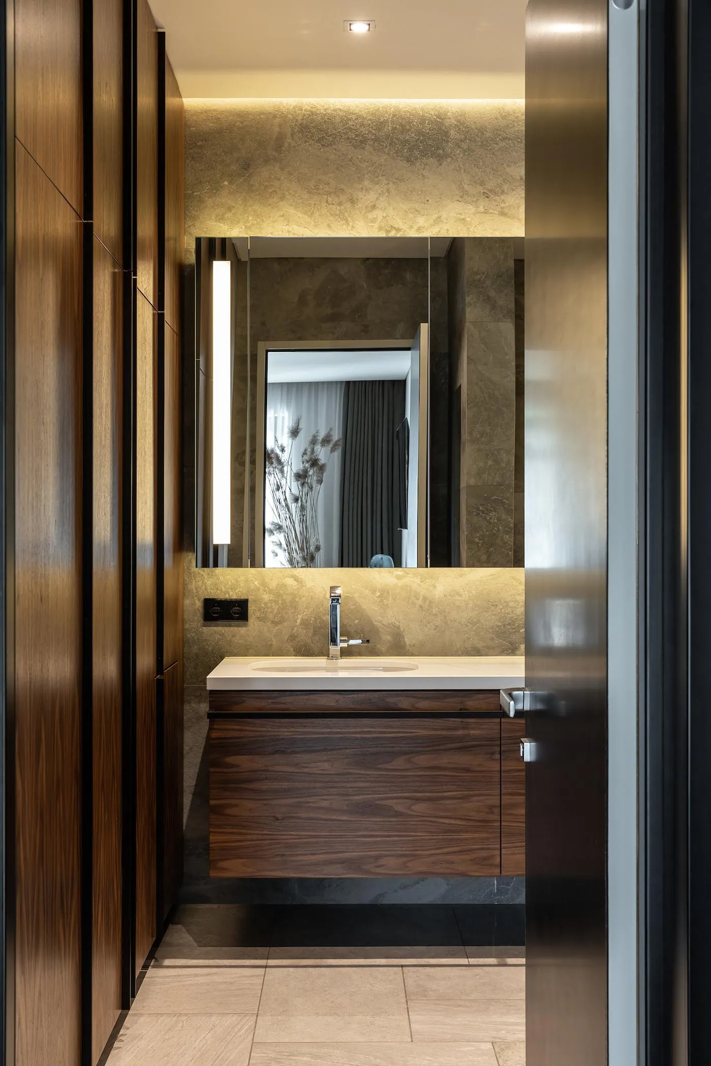 A modern bathroom featuring a wooden vanity and marble countertop.