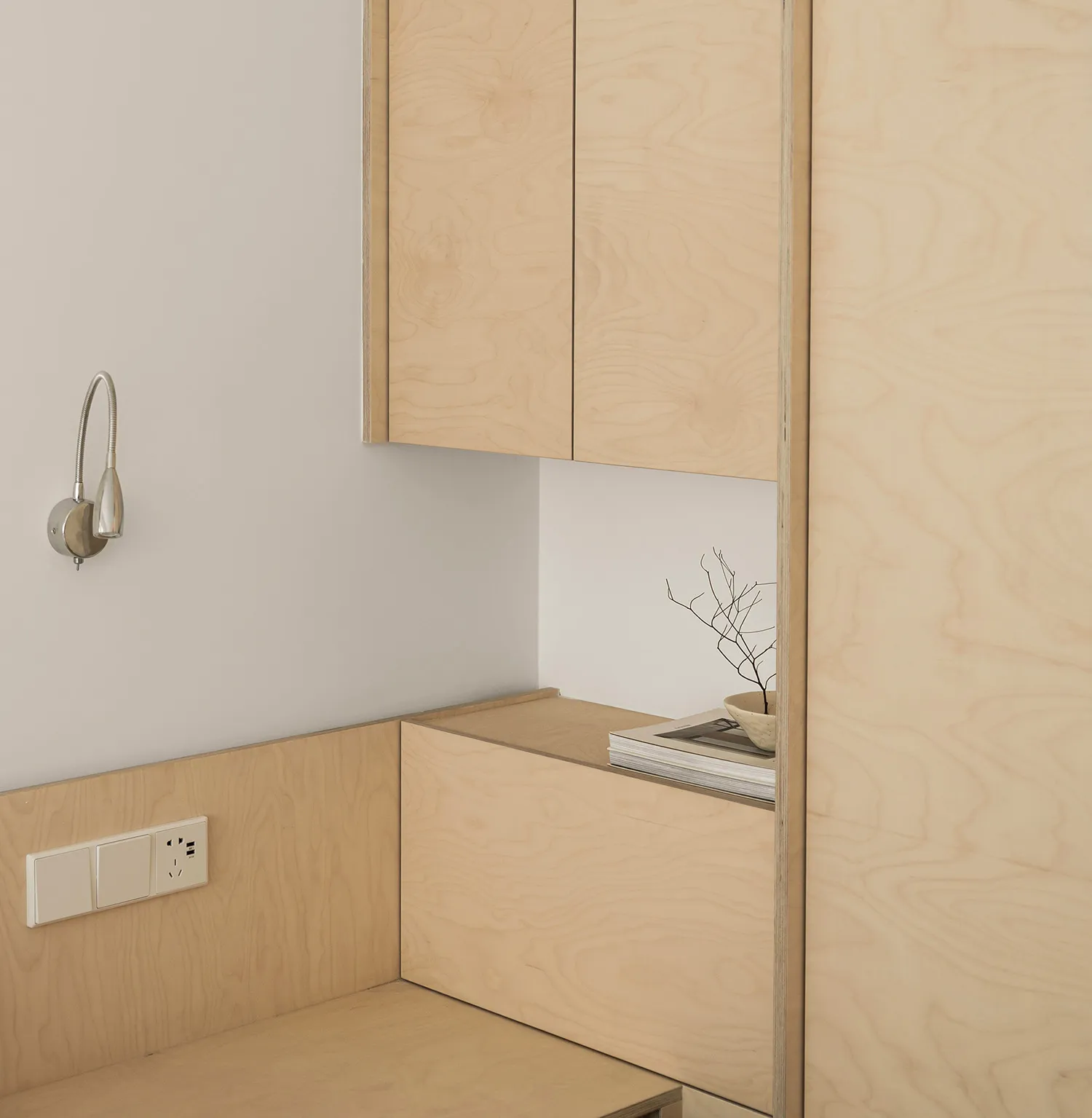 A modern minimalist residential interior with wooden furniture and minimalist design elements.