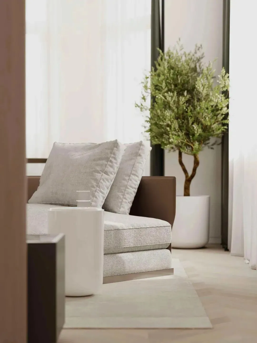 A minimalist living room featuring a comfortable grey fabric sofa with matching cushions, set against light-colored walls and