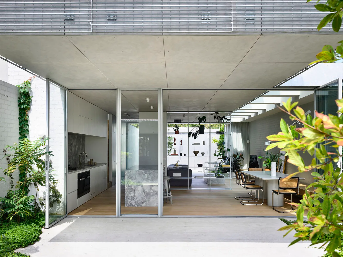Modern residential kitchen featuring glass, concrete, and marble materials for contemporary design