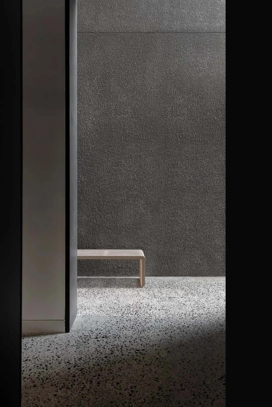 A minimalist interior designed using concrete and wool materials.