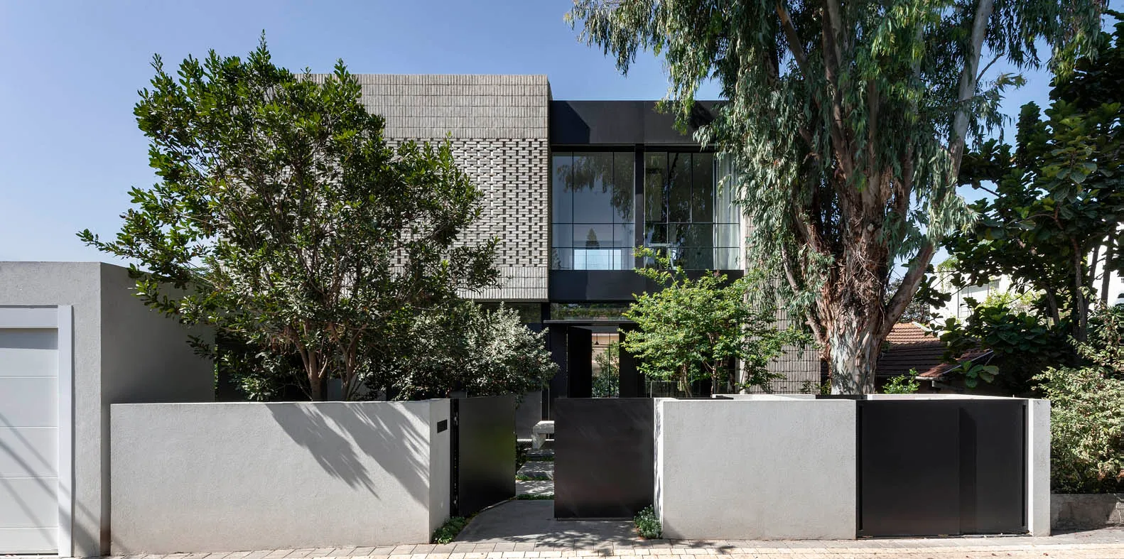 A modern house with a minimalist design, featuring concrete walls and large windows.