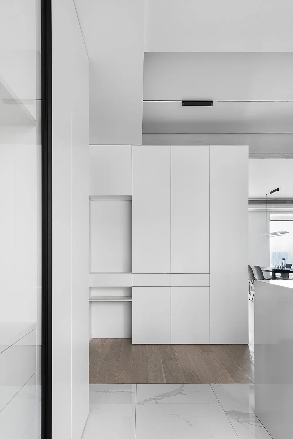 A modern, minimalist residential setting featuring white cabinets.