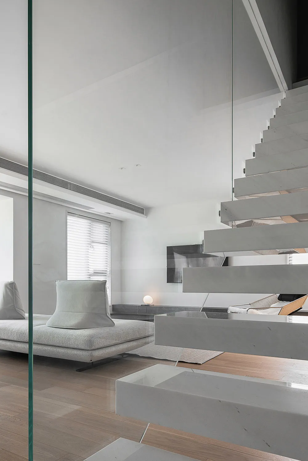 Modern living room with concrete stairs and minimalist furniture.