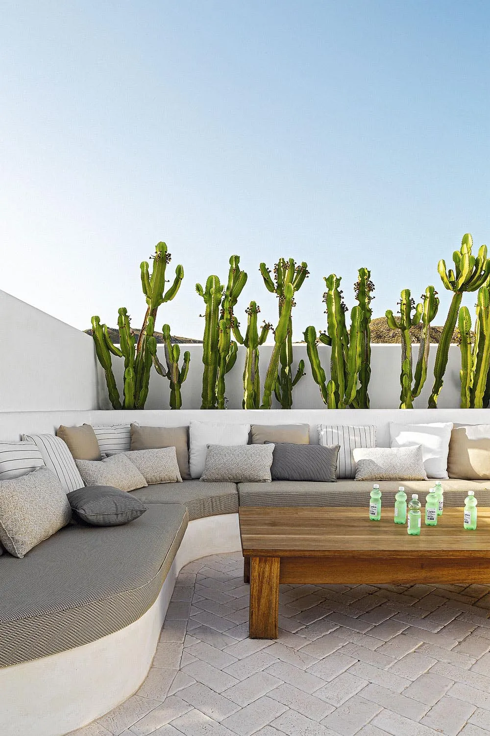 Outdoor seating area with wooden table, metal accents, and greenery.