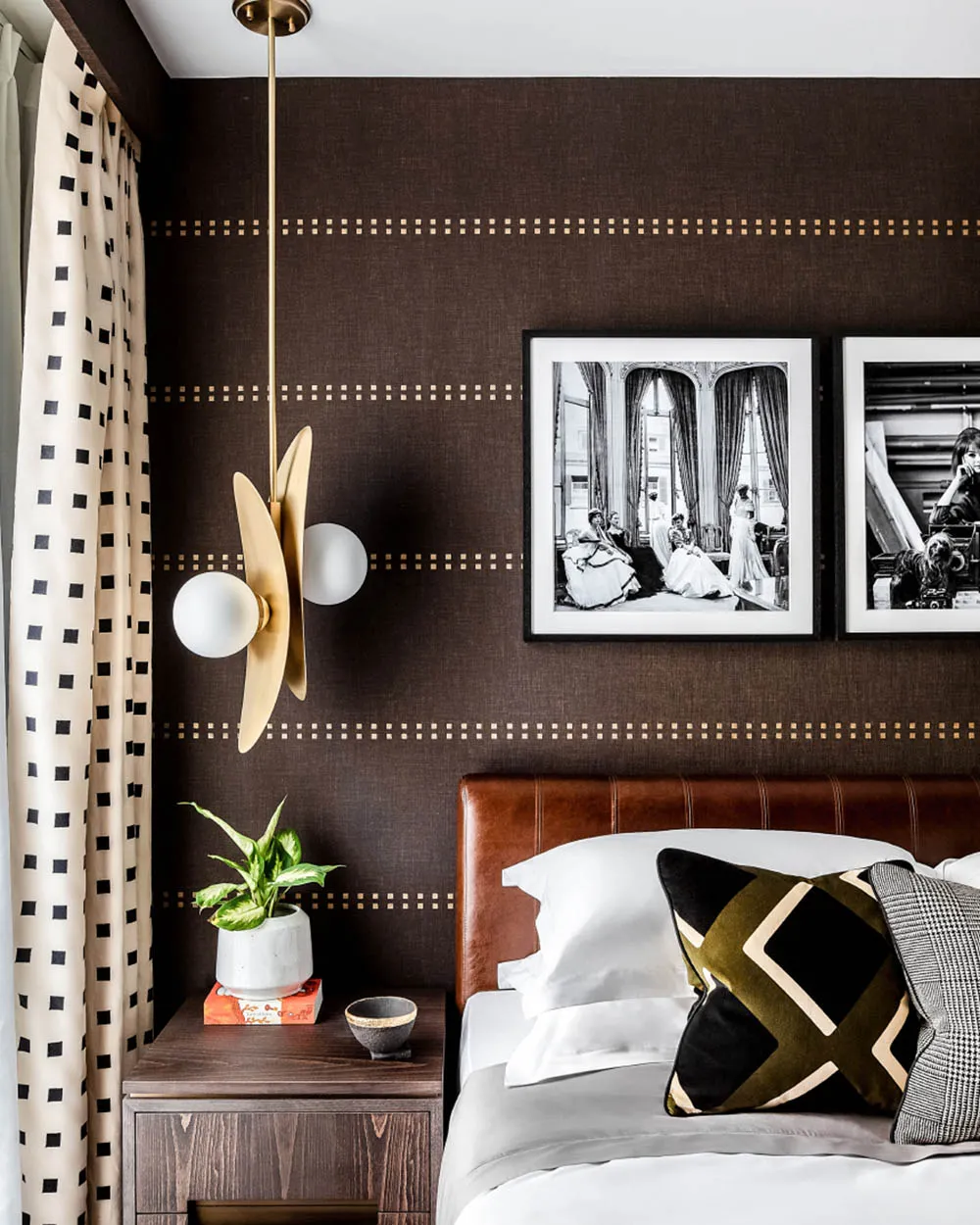A modern minimalist bedroom with a brown leather headboard, white bedding, and a stylish plant on the nightstand.