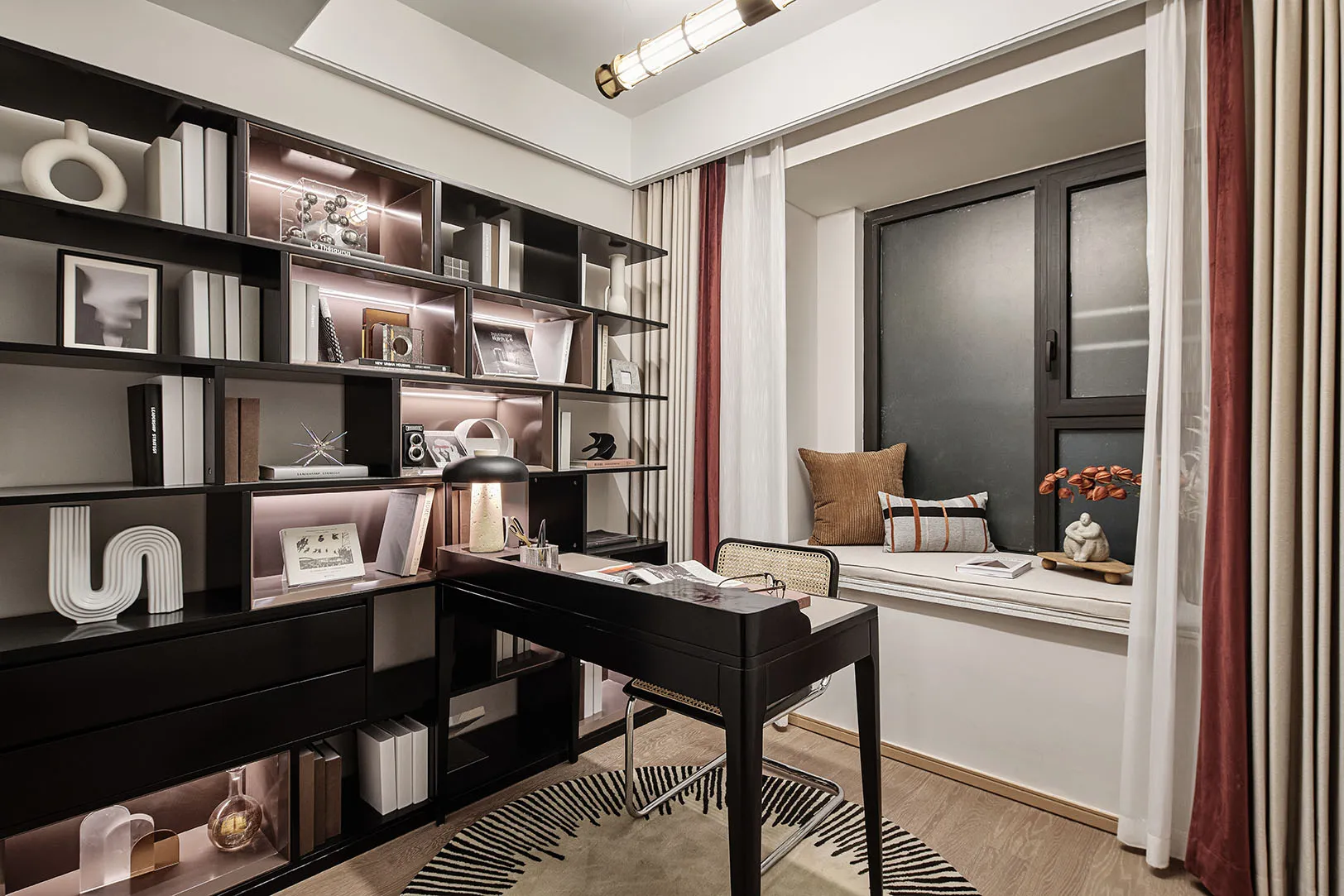 A contemporary home office with minimalist design, featuring a black desk, shelves, and a reading nook by the window.