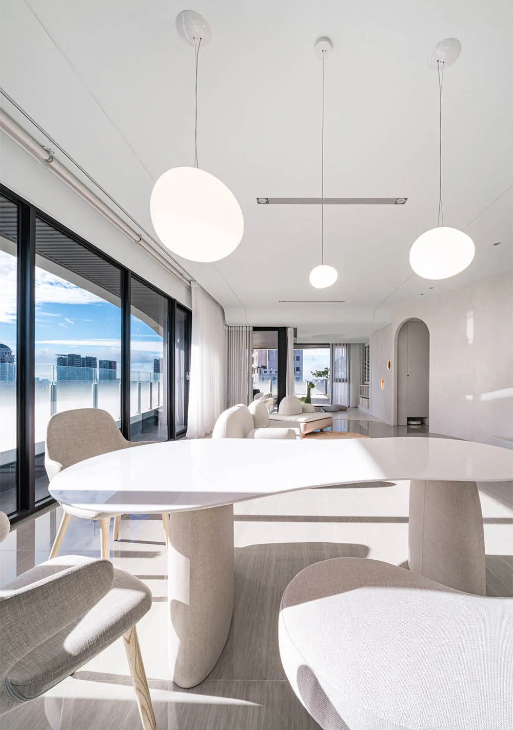 A modern living room with white furniture and minimalist design.
