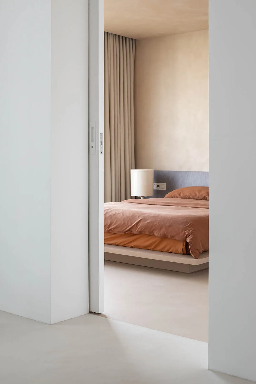 現代臥室採用混凝土地板、極簡家具與柔軟織品，呈現極簡室內設計風格。