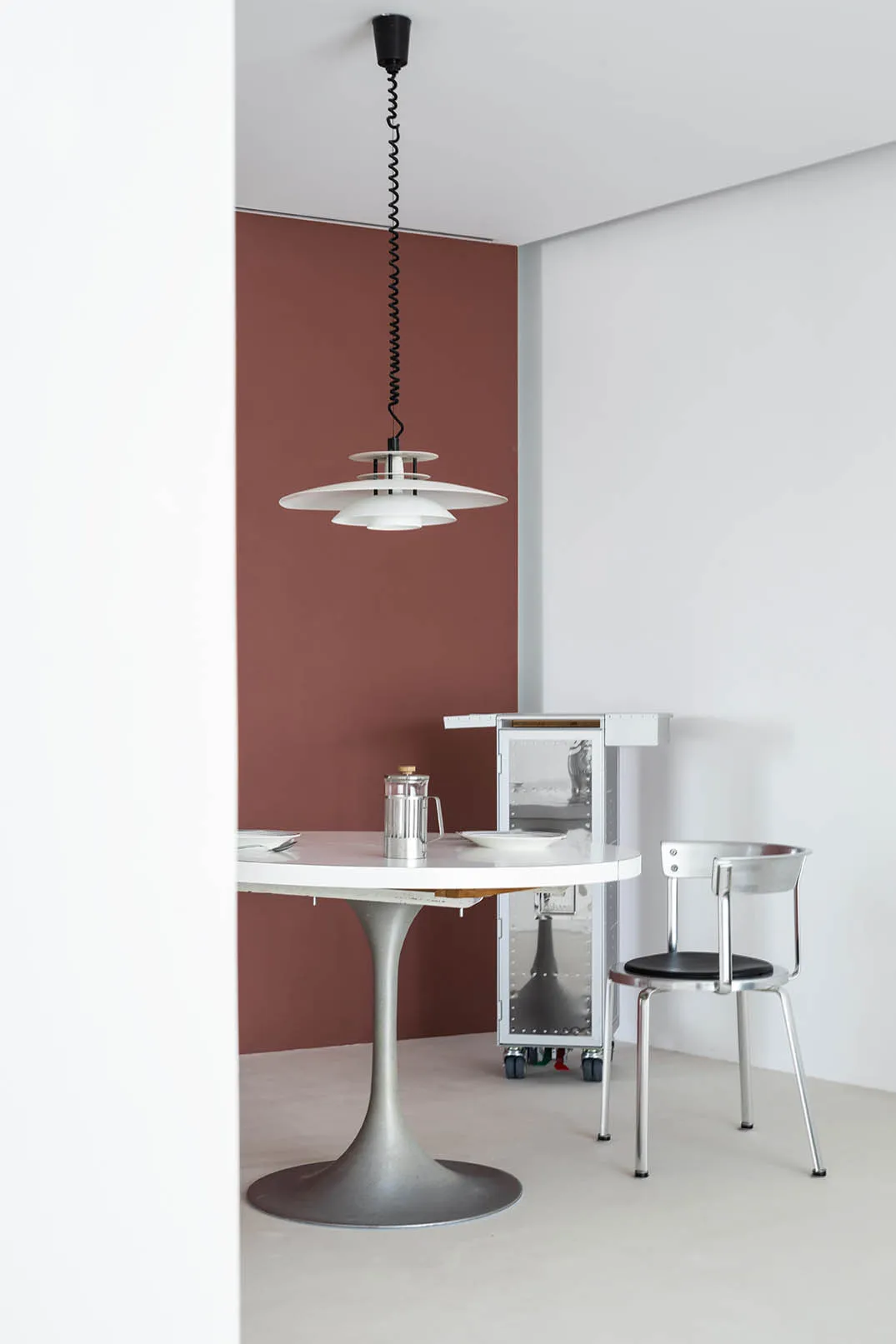 A minimalist kitchen featuring metal, glass, and wood elements.