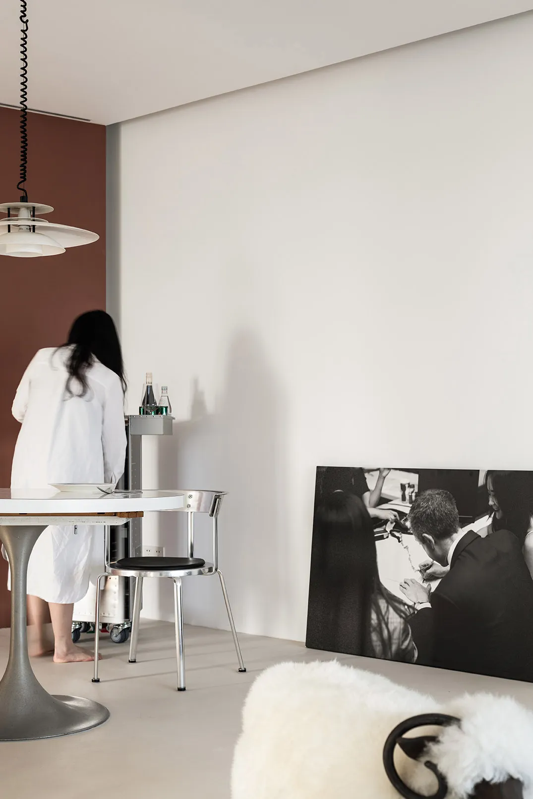 A modern living space with a minimalist design, featuring white walls, black accents, and a white ceramic floor with a black 