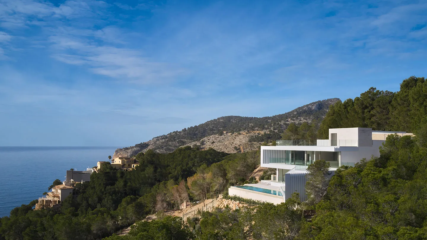 Modern house exterior with glass, concrete, and wood materials.