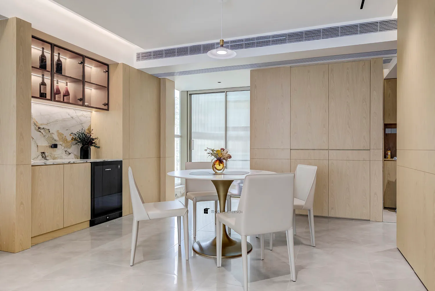 Modern kitchen and dining area with marble countertops and wooden cabinetry.