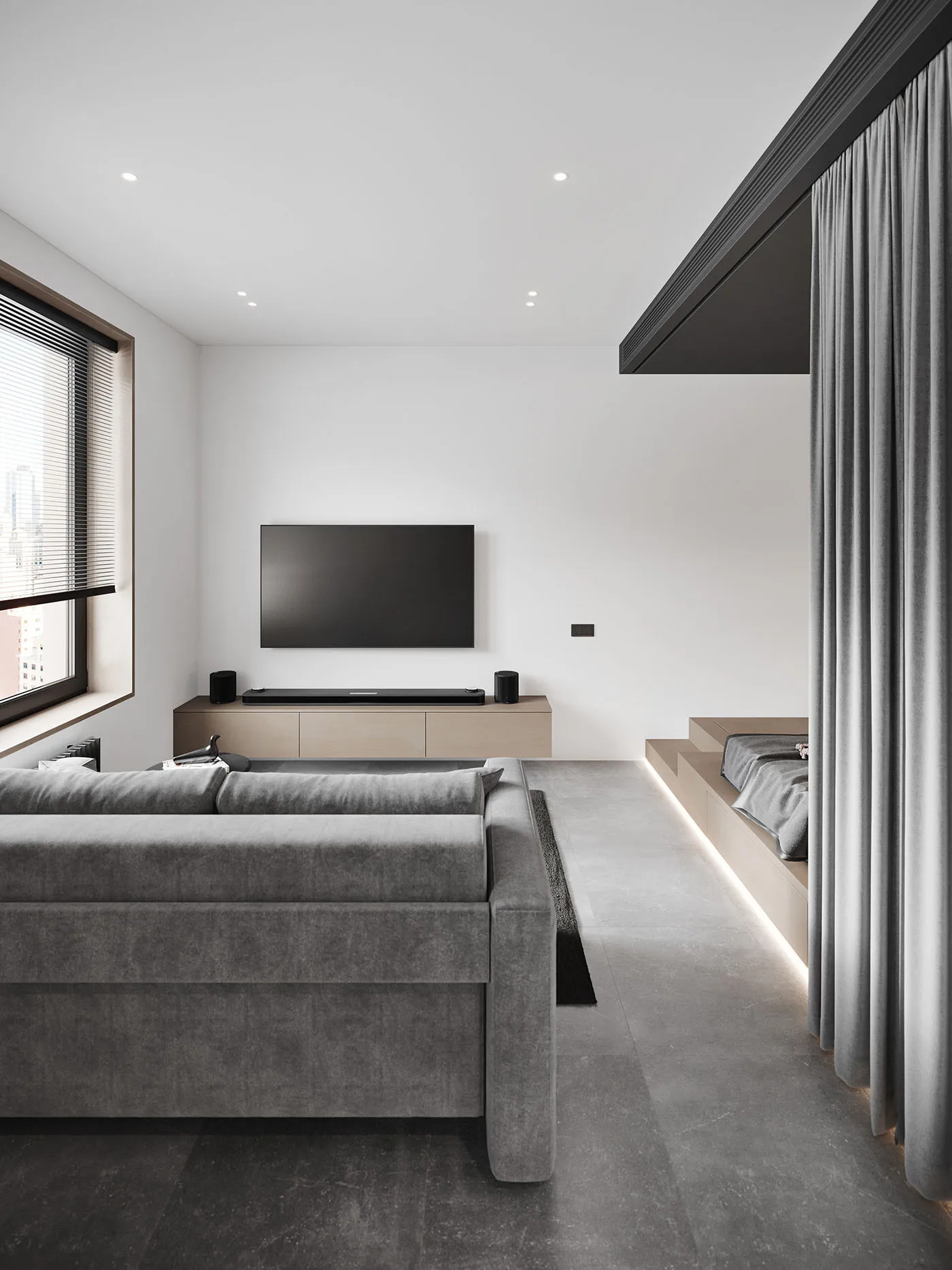 Modern minimalist living room featuring a concrete floor, grey sofa, and a television mounted on the wall.
