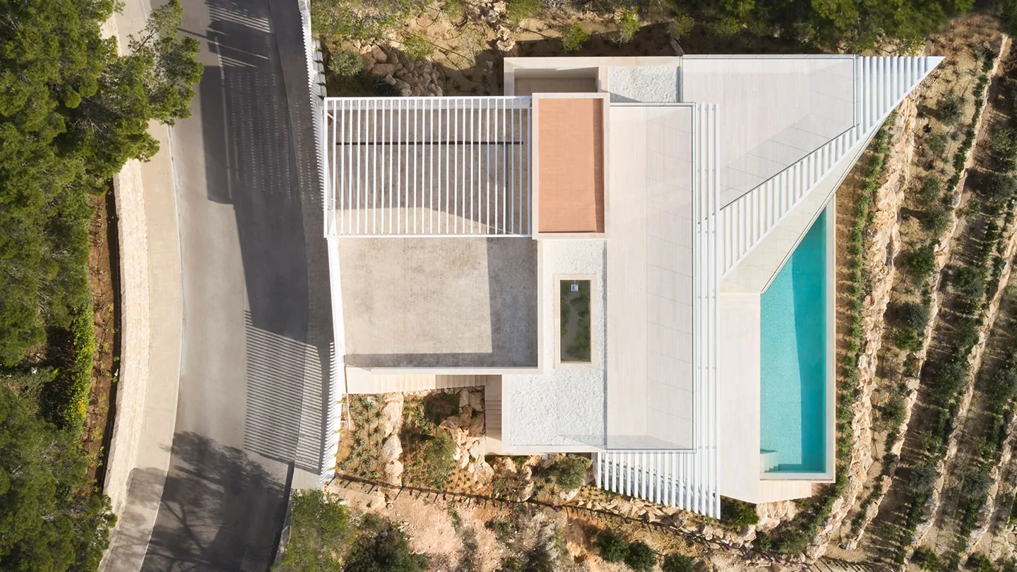 Modern residential house featuring a white, geometric structure with a white roof and a swimming pool.
