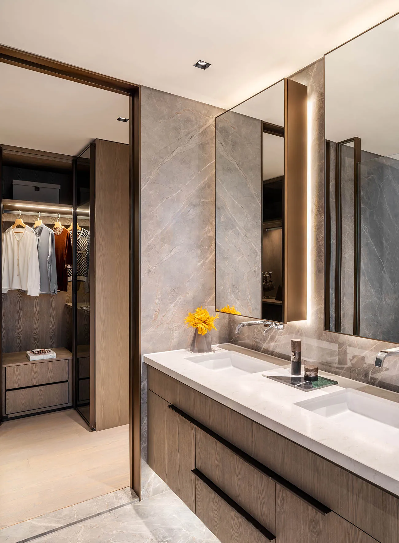 Modern bathroom with marble finishes, dual sinks, and a walk-in closet.