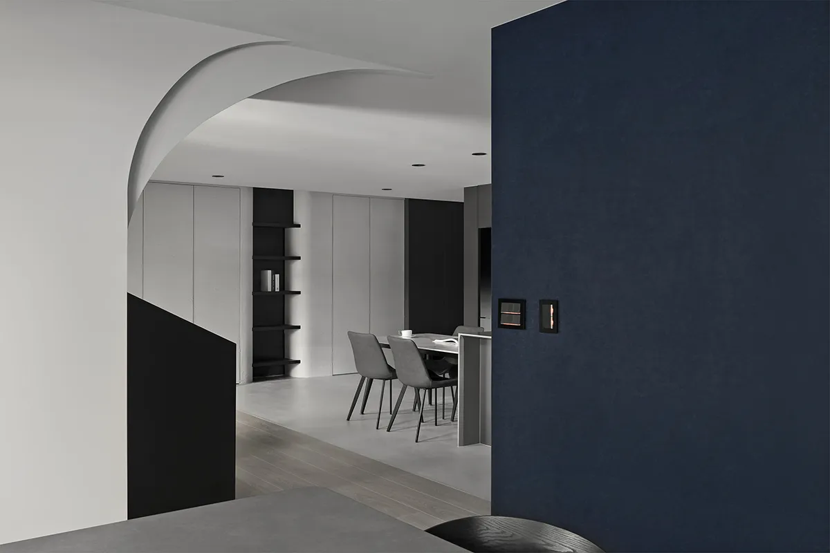 Modern minimalist dining room with concrete finishes featuring a sleek table and chairs.