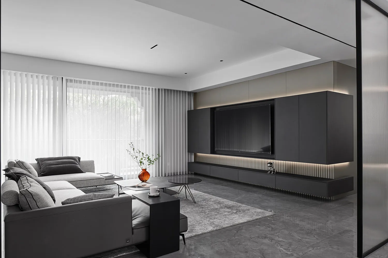 Minimalist living room with steel furniture, marble accents, and glass elements.