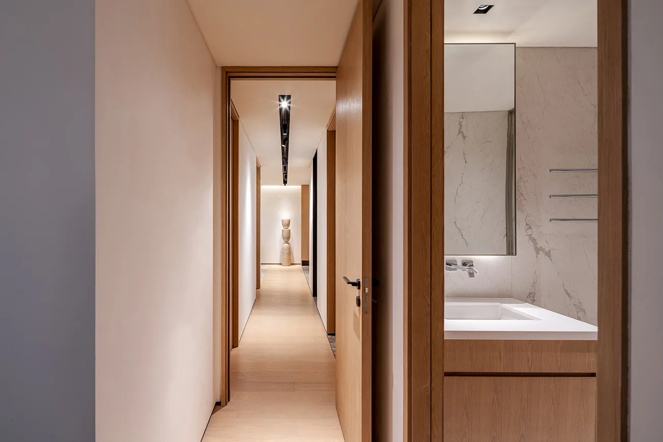 Modern minimalist bathroom featuring marble and wooden elements.