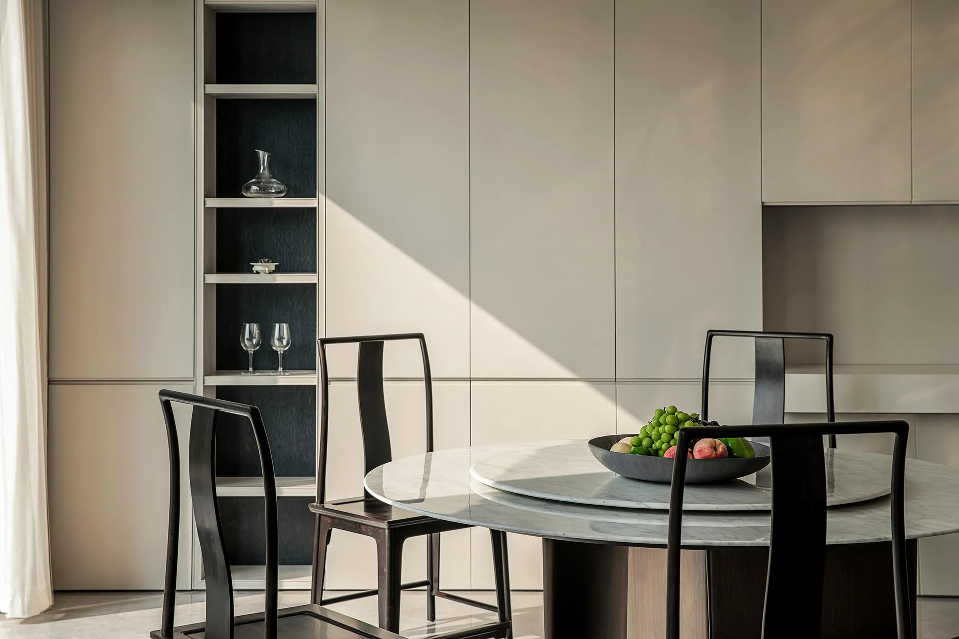 Modern dining room with marble table and wooden chairs.