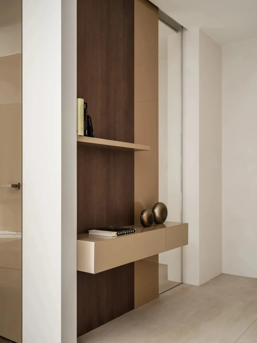 A minimalist, modern entryway featuring integrated storage and a floating console with metallic accents.