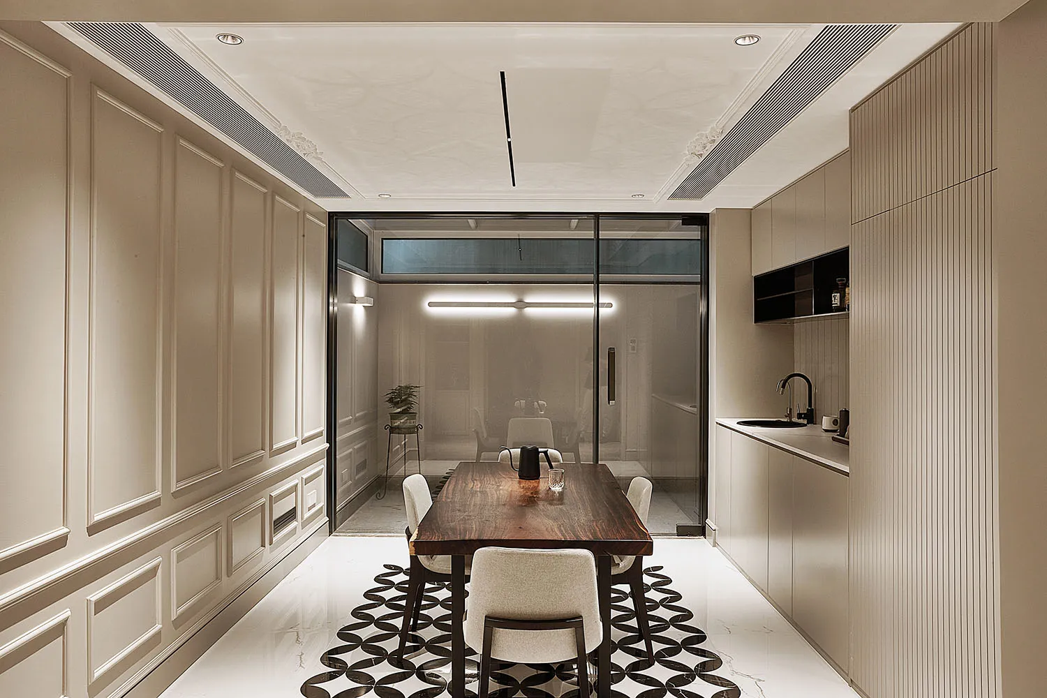 Modern kitchen and dining area with wooden dining table and marble finishes.