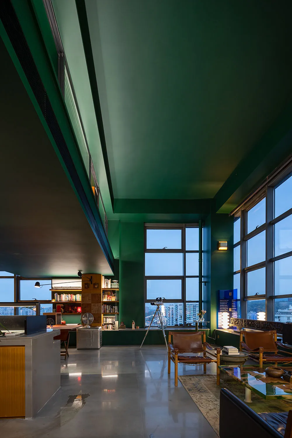 A modern living room with a concrete floor and glass windows.