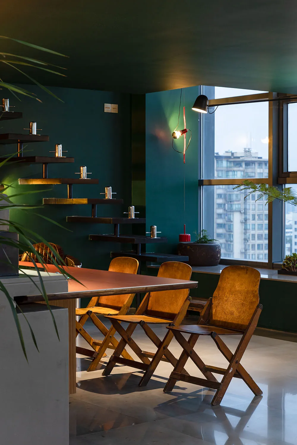 Industrial-style restaurant interior with wooden tables, metal chairs, and glass decor.