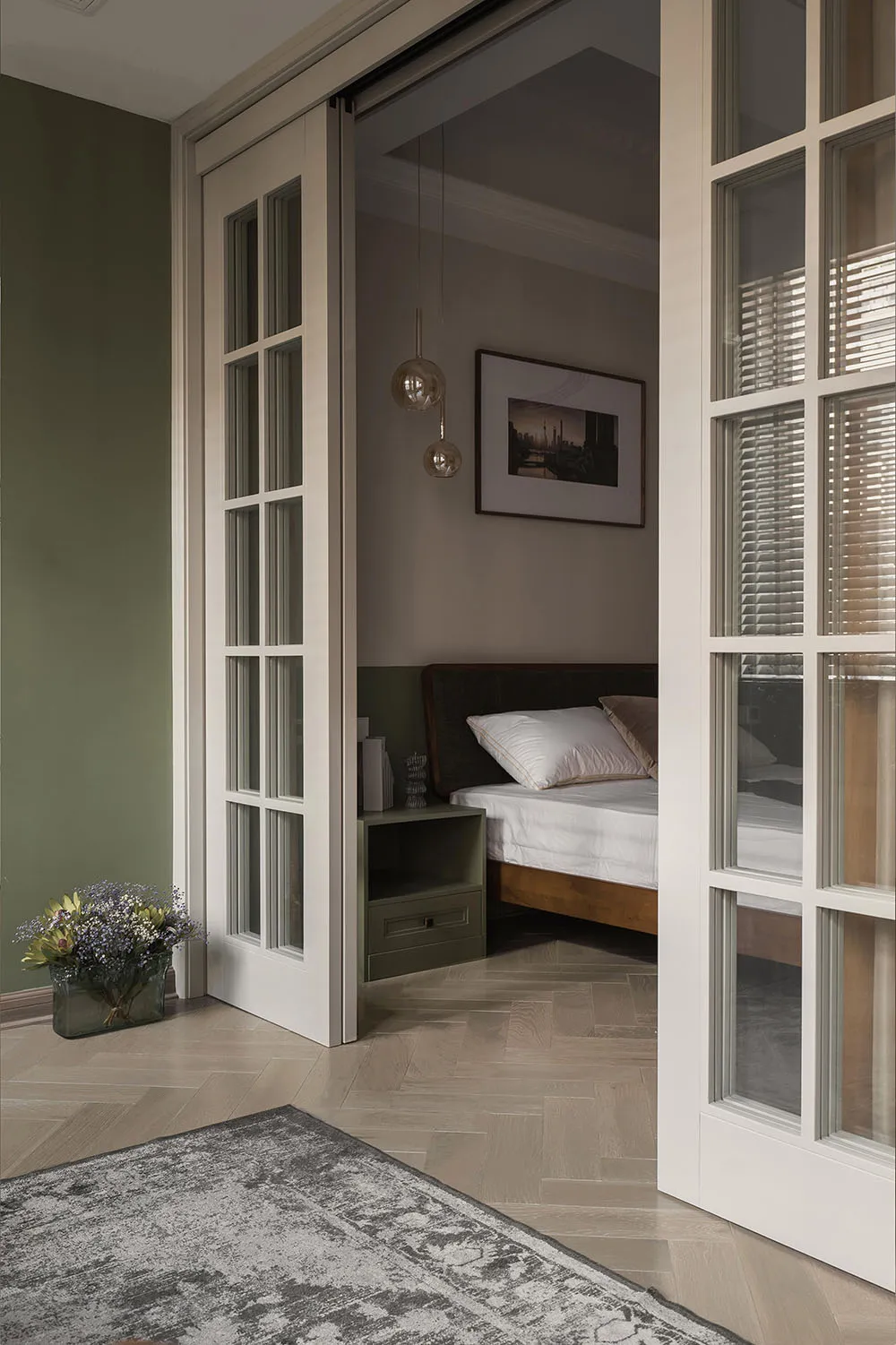 Modern bedroom with a white bed frame, green walls, and a wooden floor.