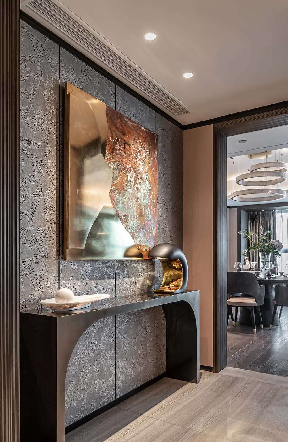 Modern entryway with metallic textured panels and contemporary art piece.
