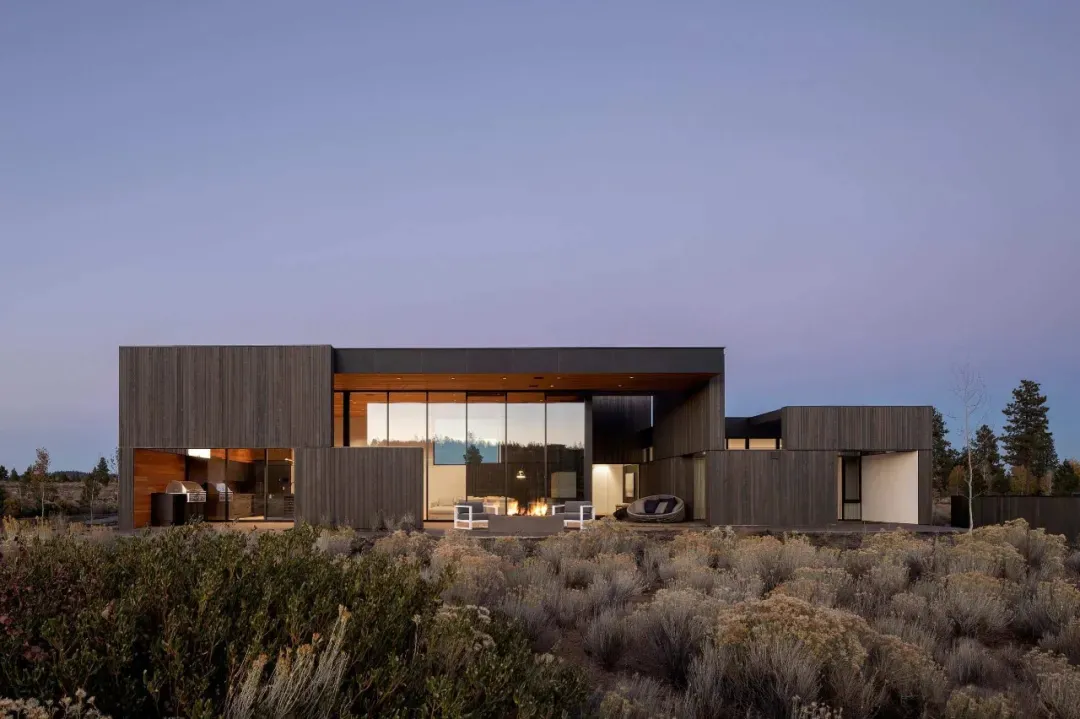 Modern residential exterior with wooden siding and large glass windows