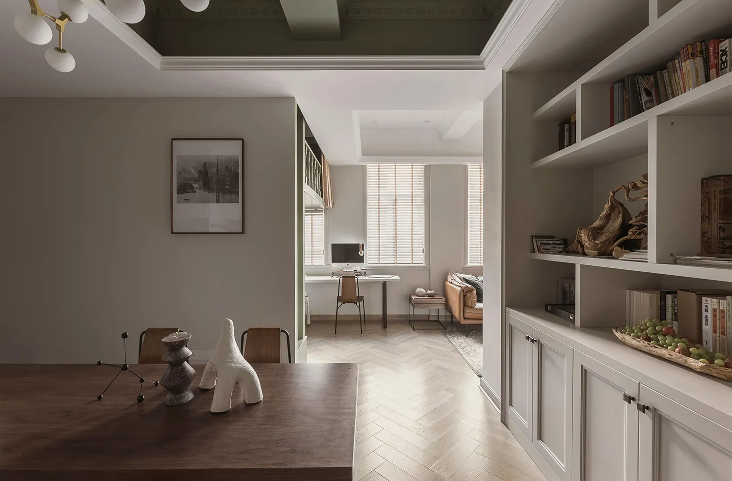 A modern living room with wooden furniture, white walls, and a bookshelf filled with books and decorative items.