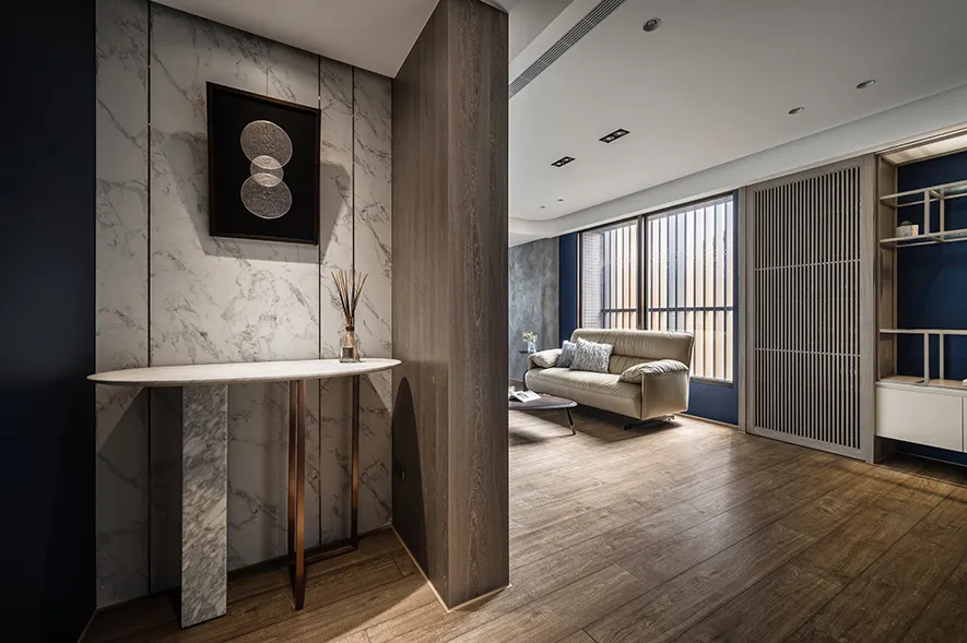Modern living room with marble walls, wooden furniture, and concrete flooring.