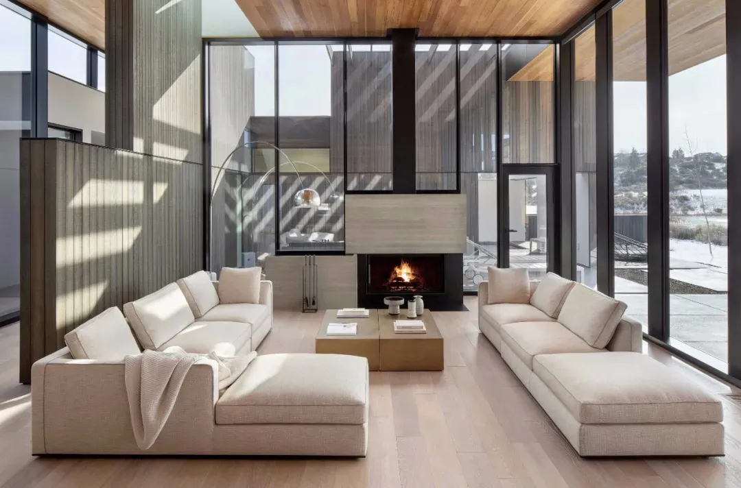 A modern living room featuring concrete walls, wooden furniture, and a wooden ceiling.