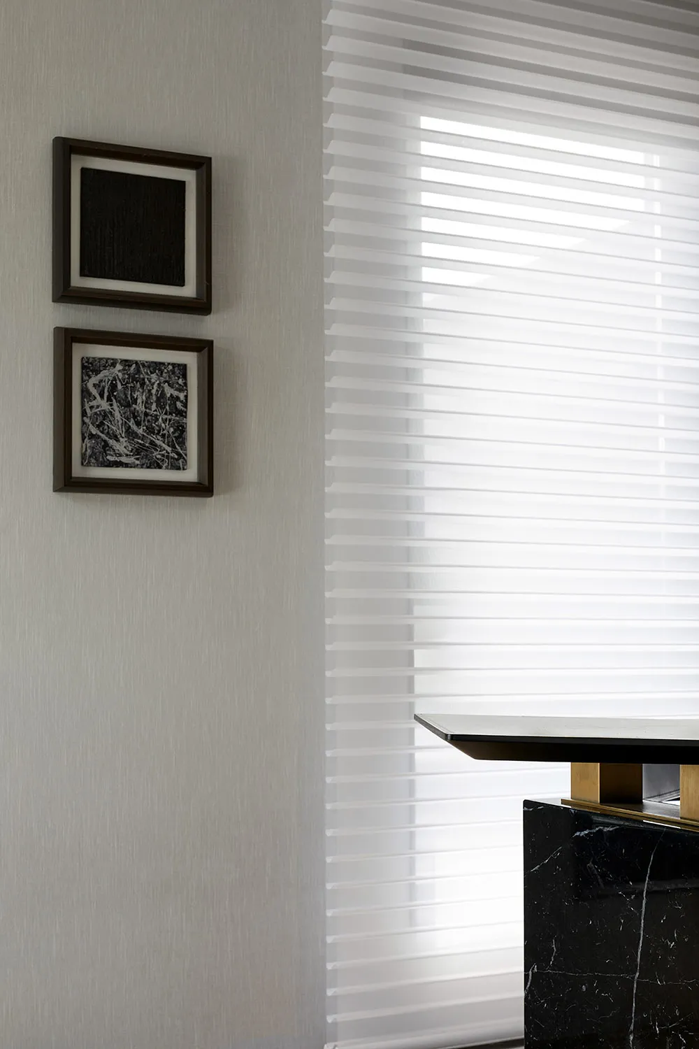 A modern apartment featuring white blinds, a black marble table, and a concrete floor.