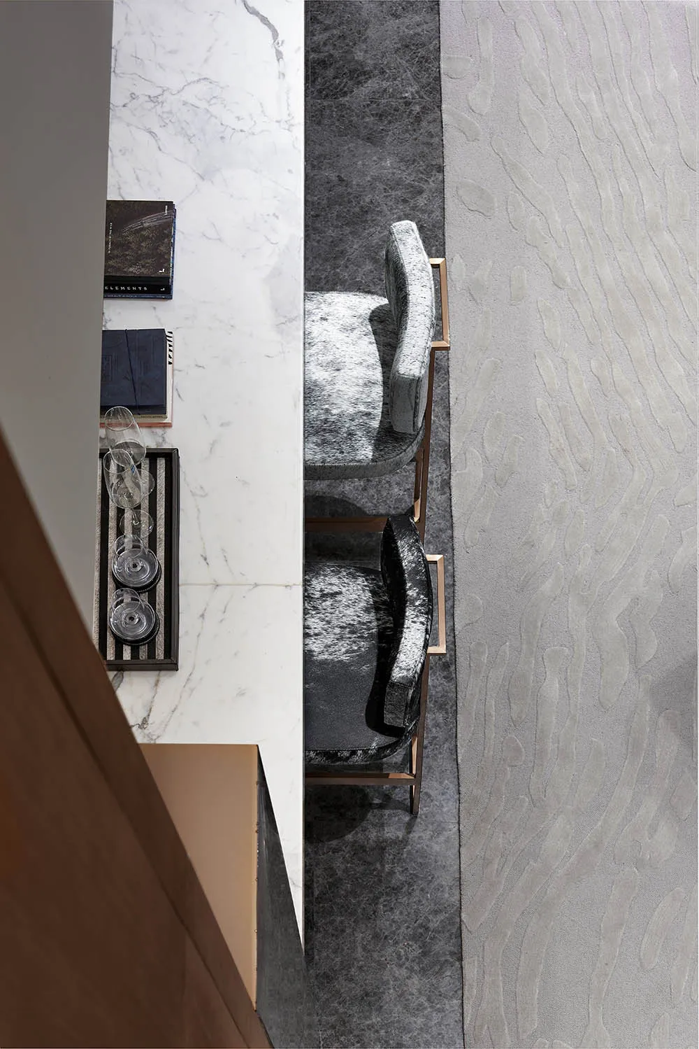 A modern dining room features marble countertops and fabric upholstered chairs with metallic frames.