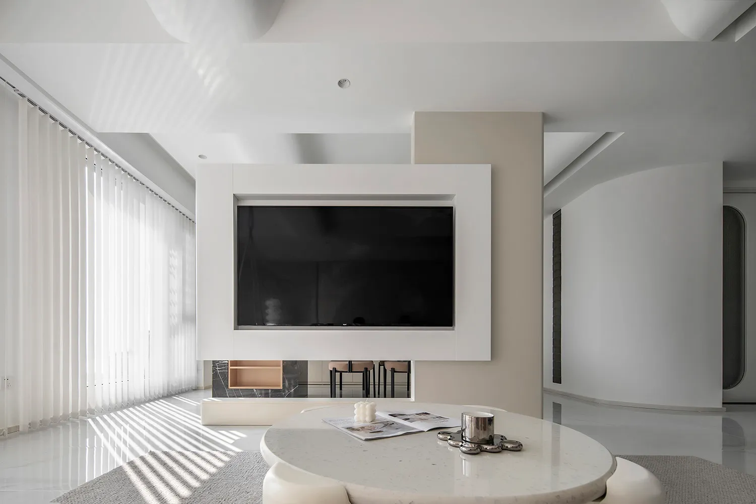 A minimalist living room with a white and black color scheme and concrete elements.