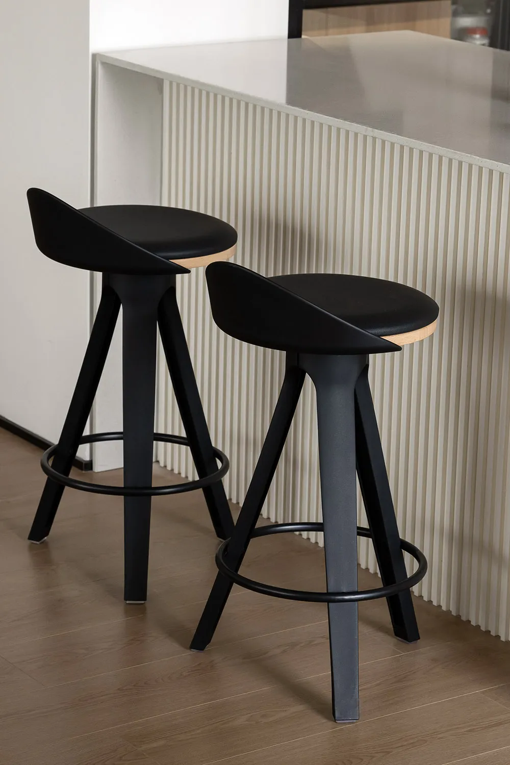 Modern industrial-style black bar stools with metal legs and wooden seats