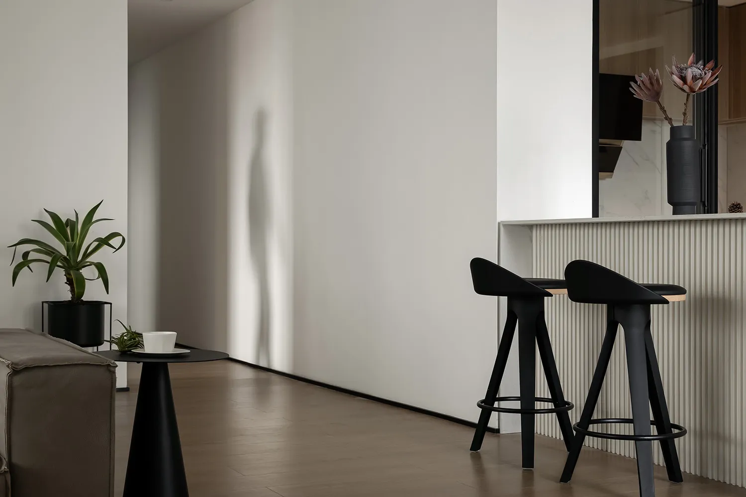 Modern kitchen with concrete countertops and wooden stools.
