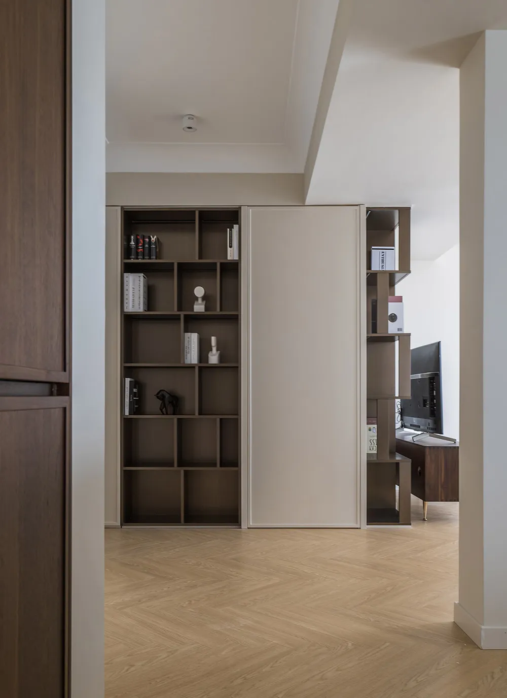 Modern living room with built-in storage shelves and a combination of wood and metal materials