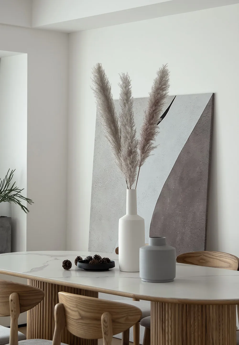 A modern minimalist dining room with wooden furniture and a marble table.