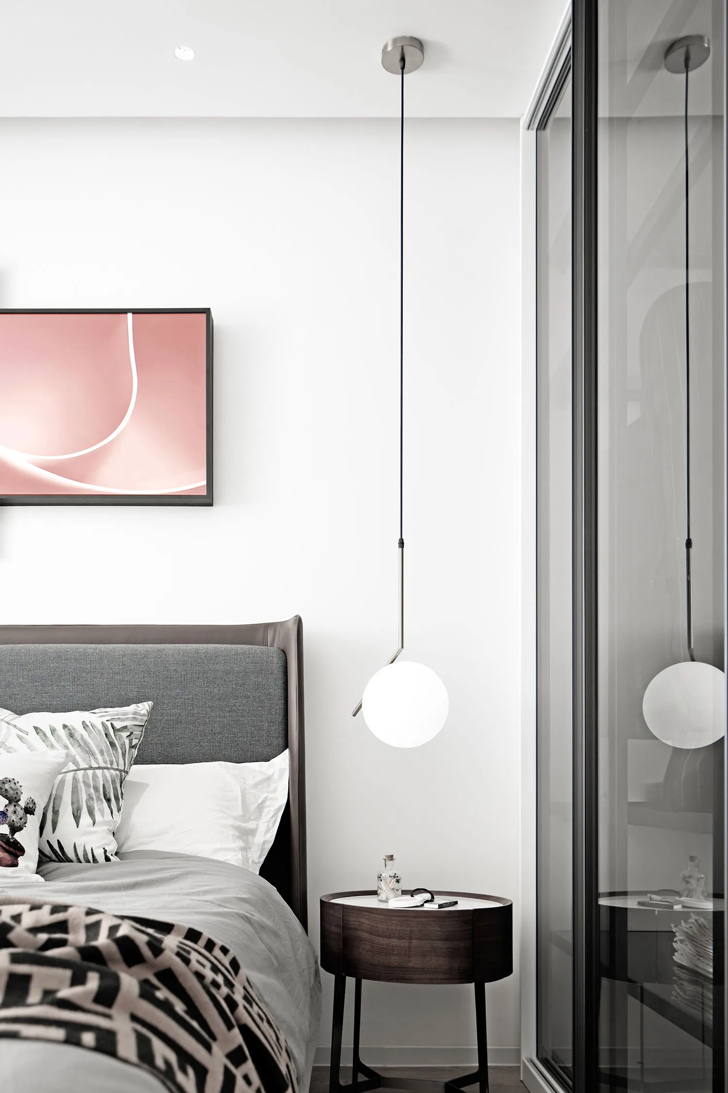 A minimalist bedroom featuring modern lighting and contemporary design elements.
