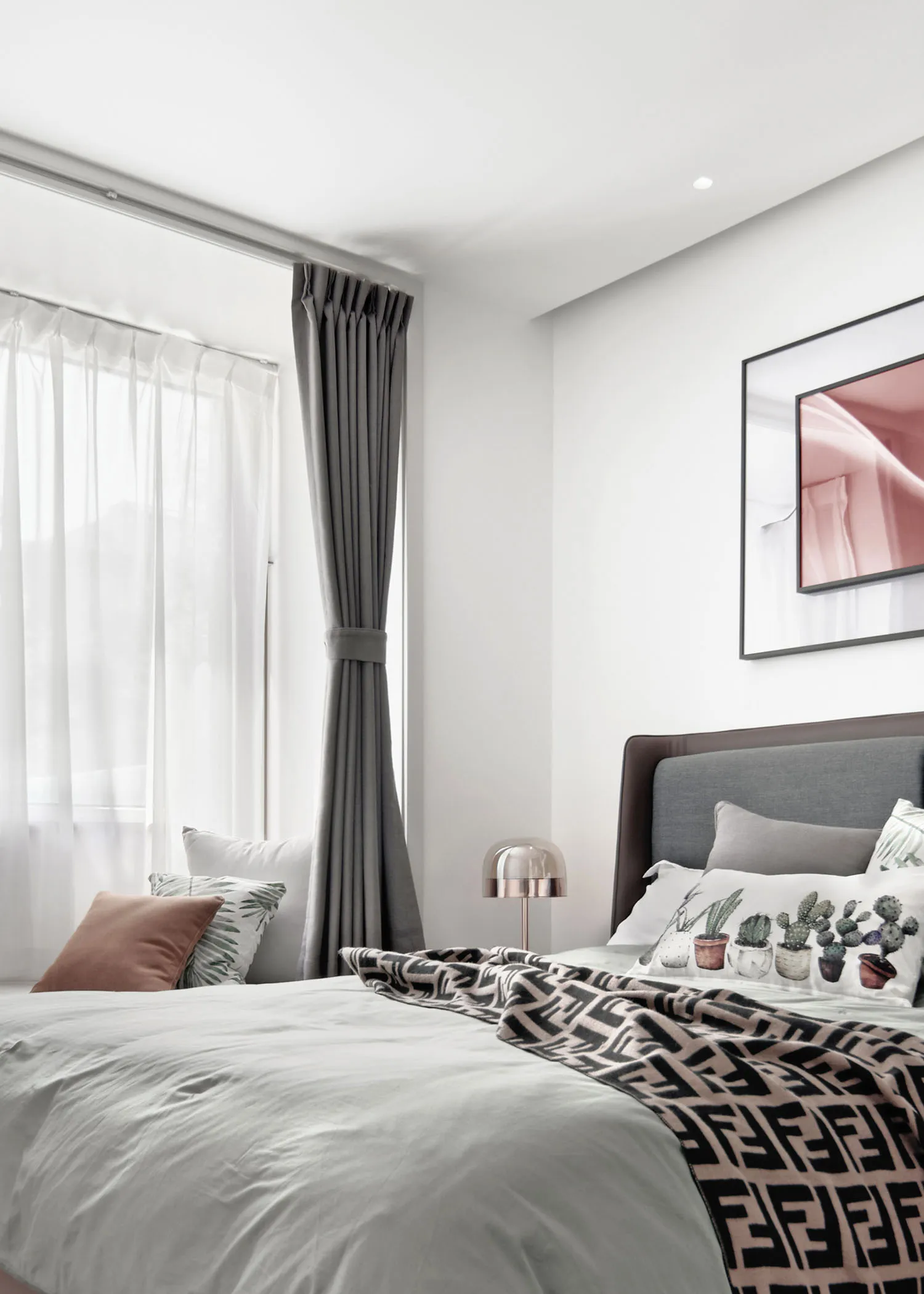 A minimalist bedroom featuring grey furniture and fabric bedding.