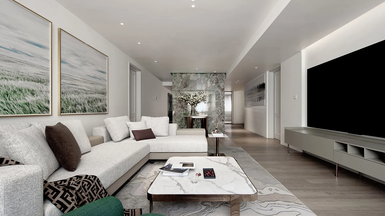 Modern apartment interior with a marble living room featuring a large sectional sofa and coffee table.