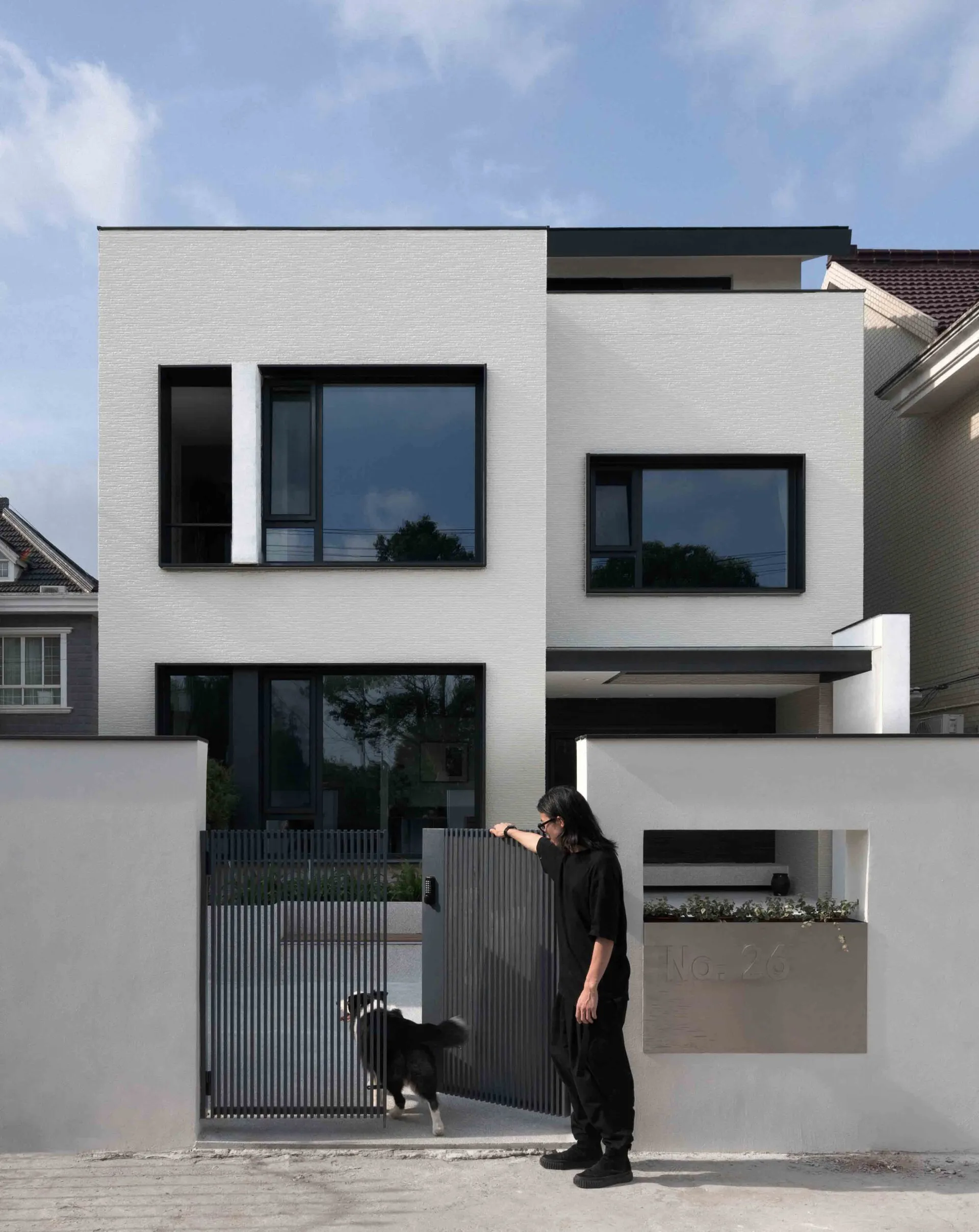 A modern, contemporary residential exterior with large windows and a minimalist design.