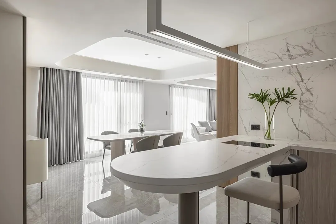 A modern kitchen with marble countertops and wooden accents.