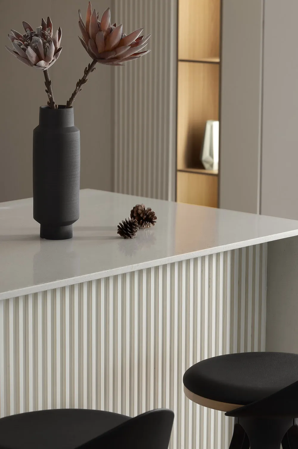 A modern minimalist kitchen with concrete countertops, wooden cabinets, and metallic accents.