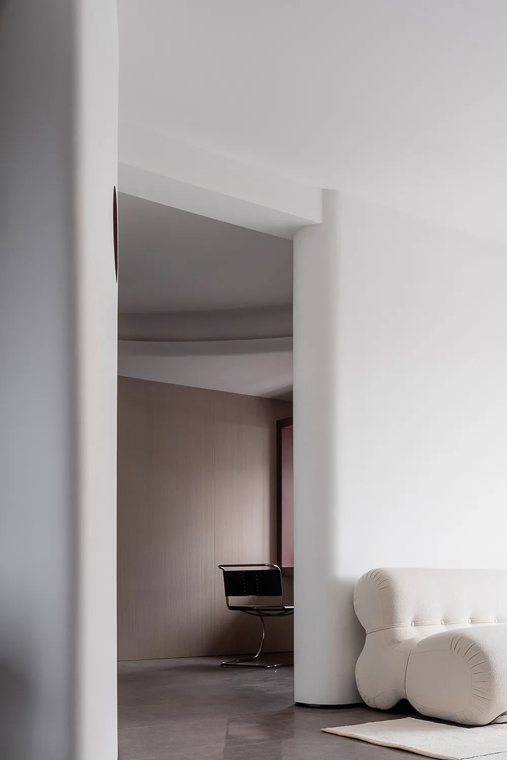 A minimalist interior design featuring concrete materials and modern furniture
