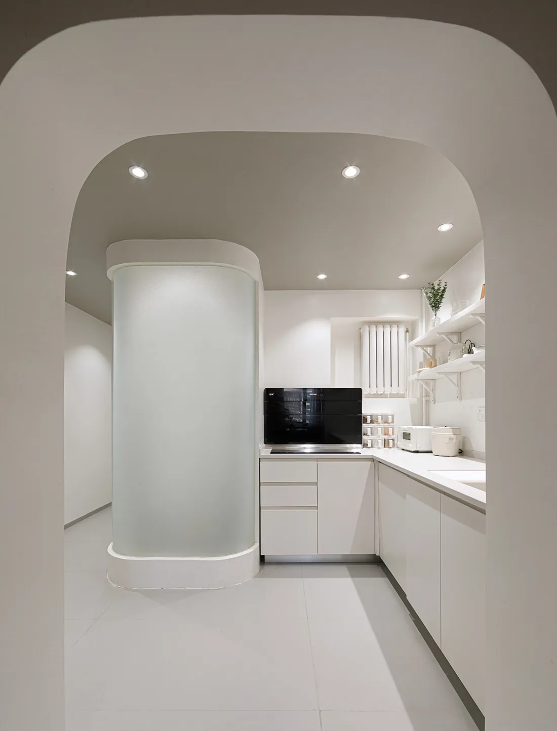 Modern kitchen with white cabinets, glass walls, and a minimalist design.